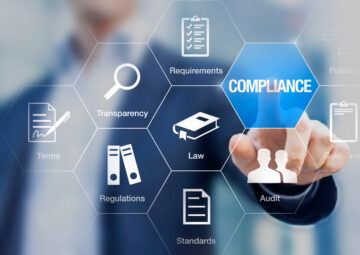 A person in business attire touches a hexagonal digital interface with the word “COMPLIANCE” highlighted. Surrounding icons and labels include requirements, transparency, terms, regulations, standards, law, audit, and guidelines.