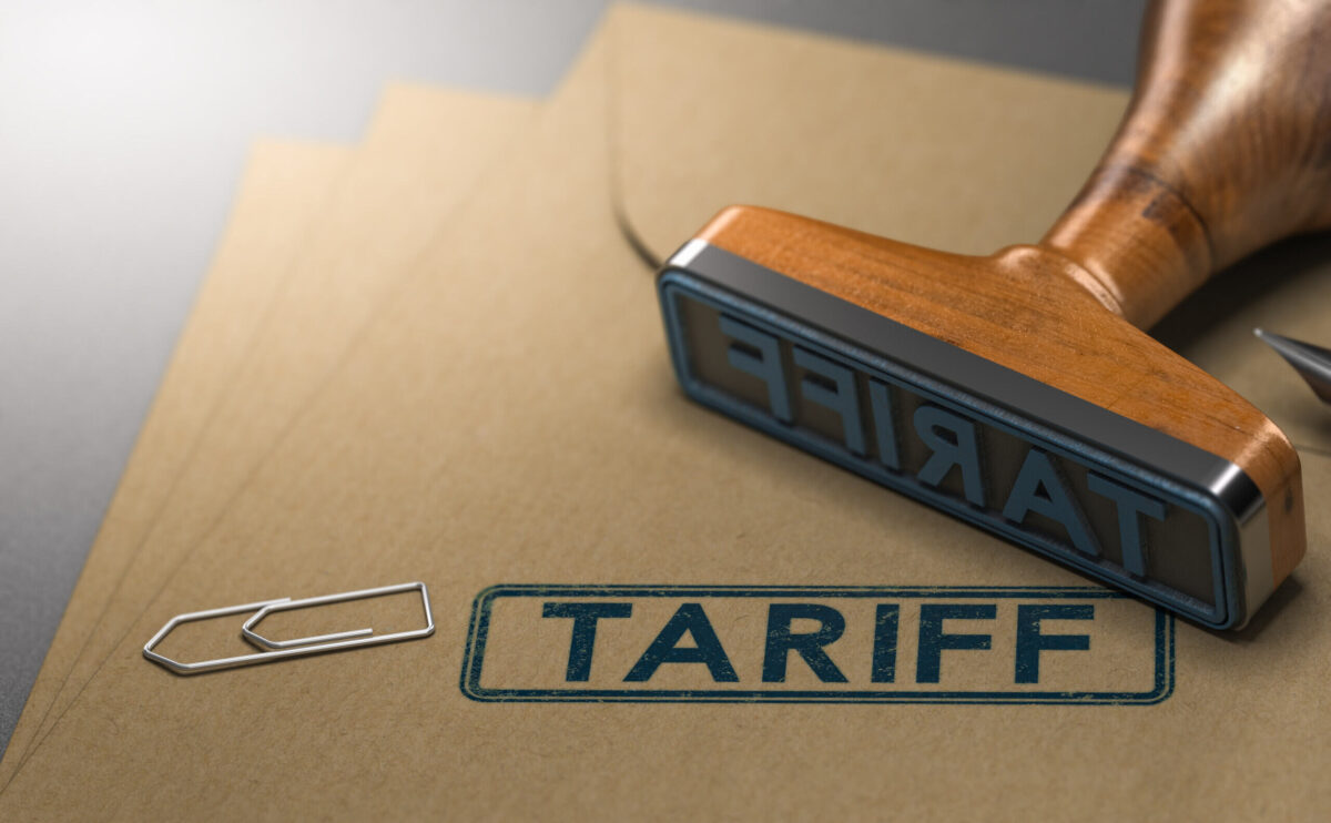 Rubber stamp imprinting the word “Tariff” on a stack of manila documents.