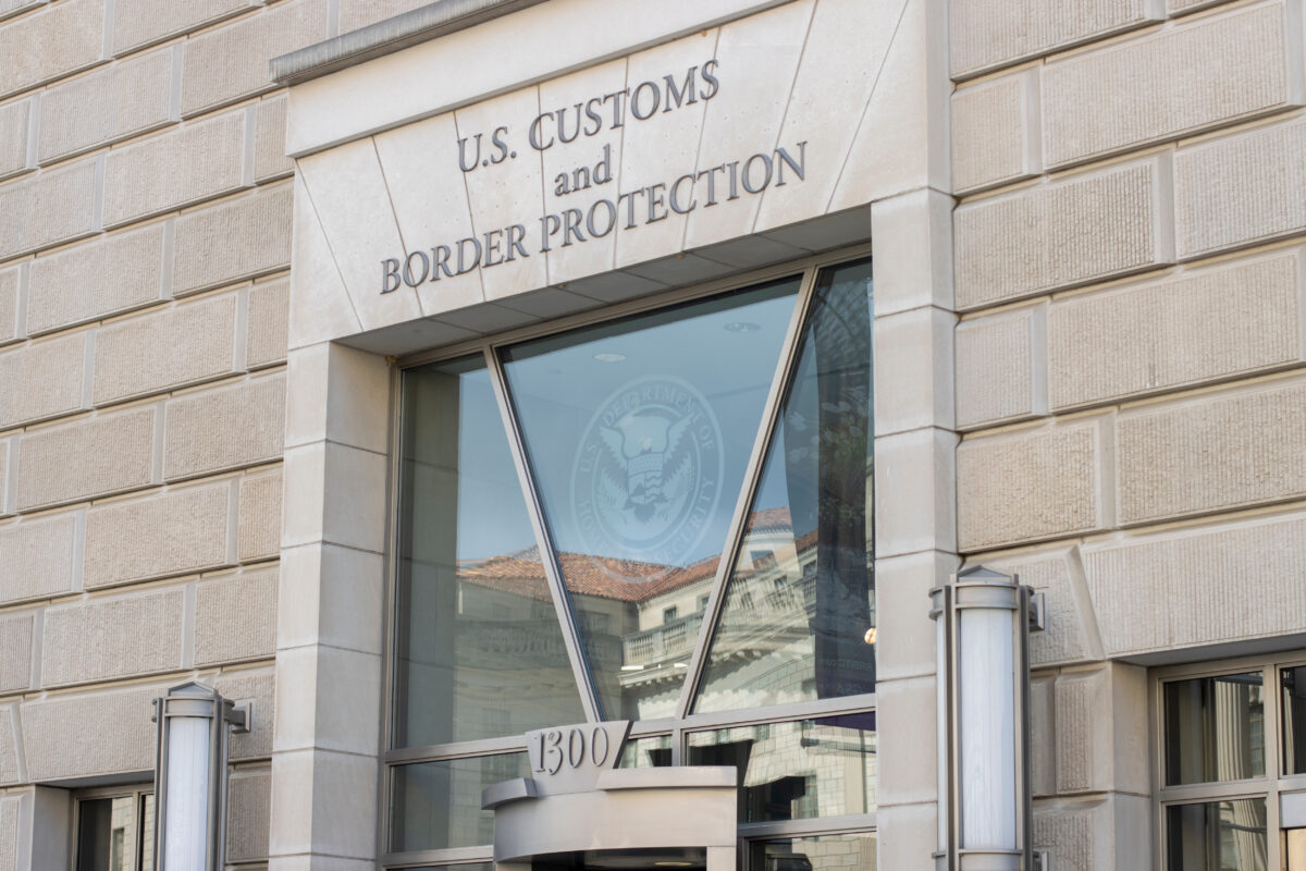 Entrance to a building labeled "U.S. CUSTOMS and BORDER PROTECTION" with address "1300" above the door.